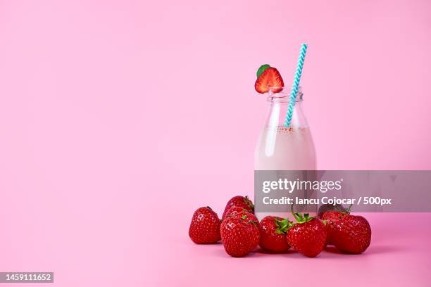 strawberry smoothie or milkshake in glass jar with berries on pink background healthy summer drink,romania - strawberry smoothie stock pictures, royalty-free photos & images
