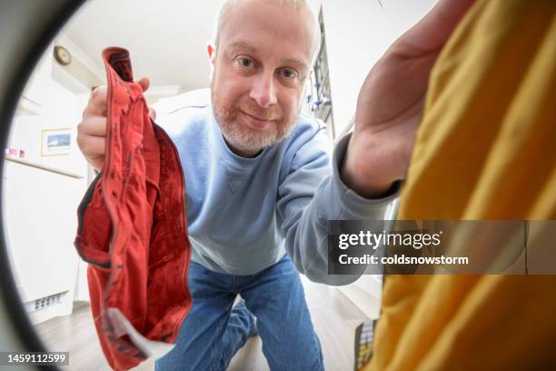 mann lädt seine waschmaschine mit schmutziger wäsche, pov-schuss - blick durch kameraobjektiv stock-fotos und bilder