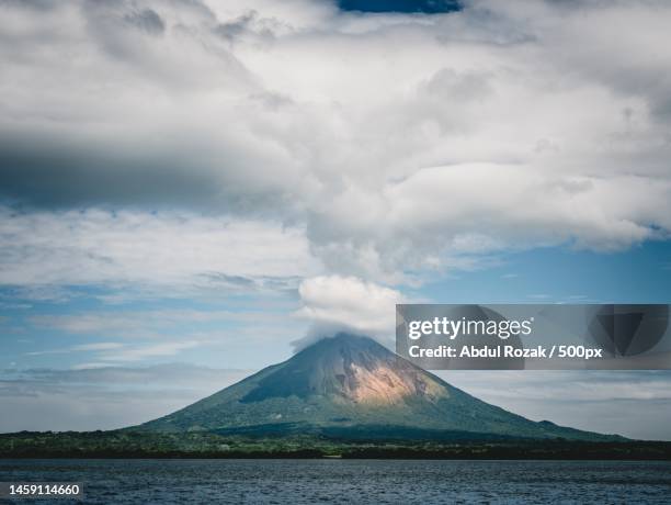 scenic view of volcanic mountain against cloudy sky,indonesia - vulcanus römischer gott stock-fotos und bilder