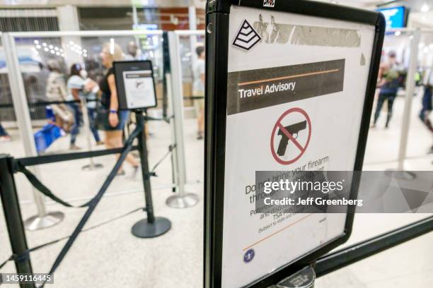 Miami, Florida, Miami International Airport MIA terminal, Transportation Security Administration TSA, check-point, travel advisory sign, firearms...