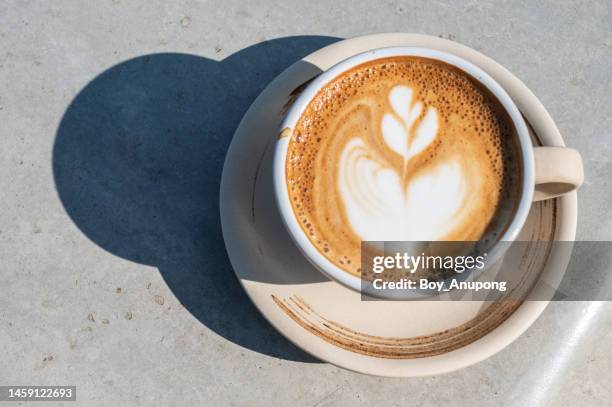 a cup of latte coffee on table. - enjoying coffee cafe morning light stock pictures, royalty-free photos & images