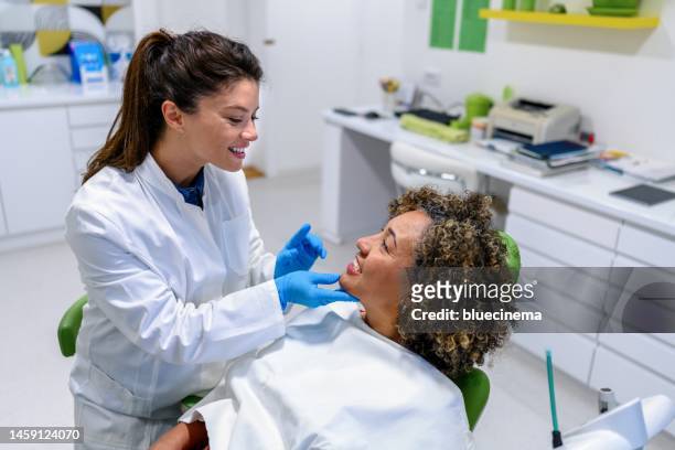mature woman having teeth examining at dentist - dentists chair stockfoto's en -beelden