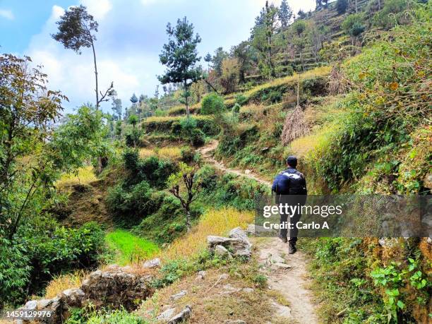 man hiking in rural landscape, nepal valley - nepal trekking stock-fotos und bilder