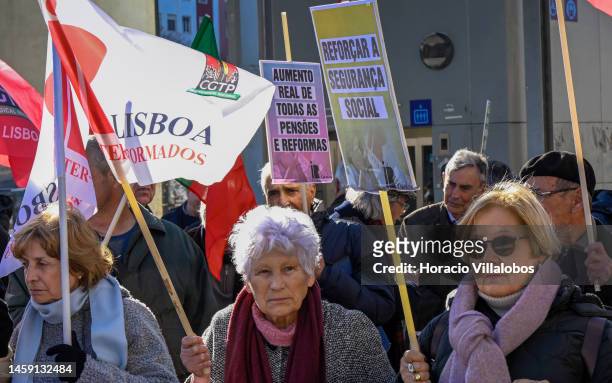 Pensioners hold posters and flags while gathering to protest in Alameda Dom Afonso Henriques against the rising cost of living on January 24 in...
