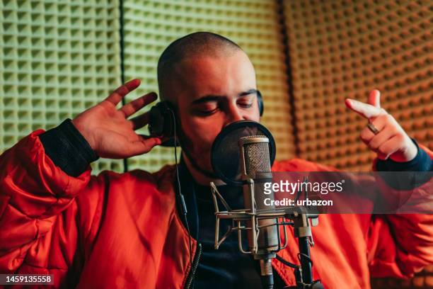 young man singing on the microphone in the studio - white rapper stock pictures, royalty-free photos & images