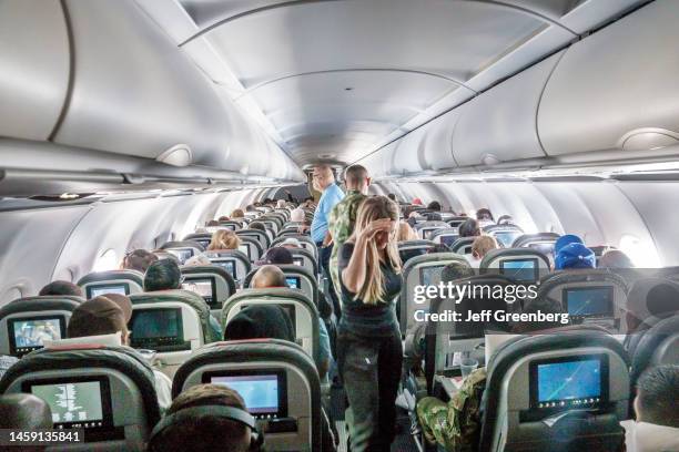 Miami, Florida, Miami International Airport MIA terminal, American Airlines, passengers standing in aisle while inflight.