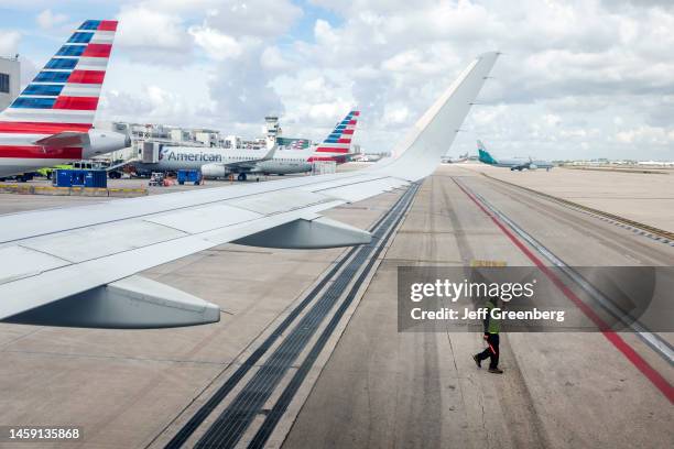 Miami, Florida, Miami International Airport, tarmac ramp ground crew directing pilot, aircraft wing .