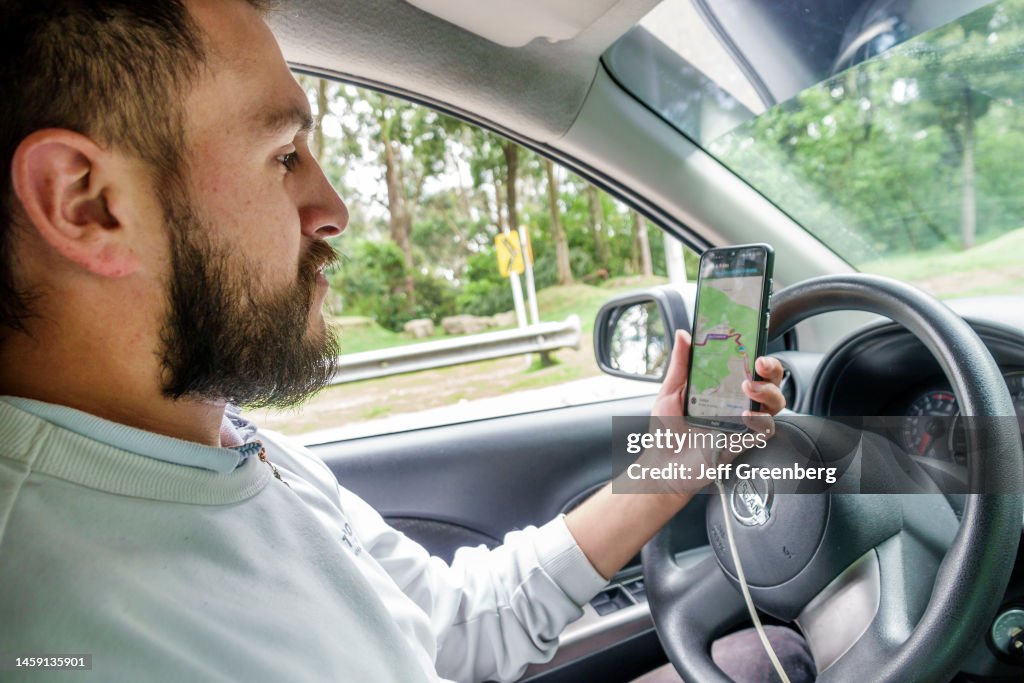 Bogota, Colombia, Santa Fe, Uber driver using mobile app and GPS to check destination and directions