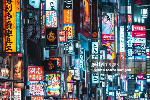 illuminated neon signs in shinjuku, tokyo, japan - tokio fotografías e imágenes de stock