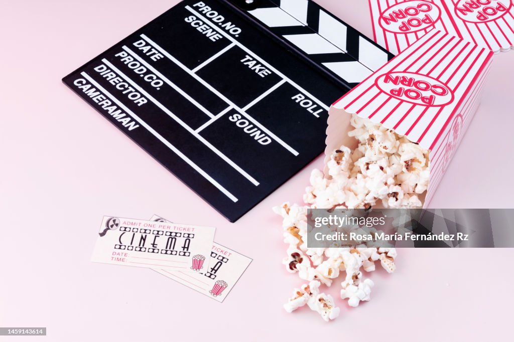 Film Slate, Movie Tickets and Popcorn on Pink Background