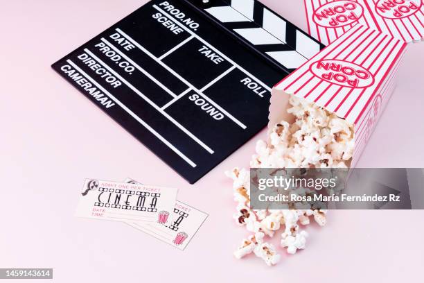 film slate, movie tickets and popcorn on pink background - industria cinematográfica fotografías e imágenes de stock