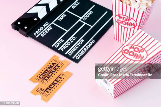 film slate, movie tickets and popcorn on pink background - divergent film fotografías e imágenes de stock