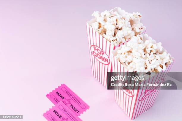 high angle view of movie tickets and popcorns on pink background - film set stockfoto's en -beelden