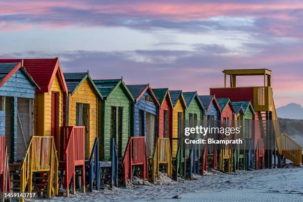 vibrant sunrise over the colorfully painted beach huts on 
muizenberg beach at the base of the cape peninsula outside cape town, south africa - cape point stock pictures, royalty-free photos & images