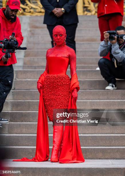 Doja Cat wears red off shoulder dress, red boots outside Schiaparelli during Paris Fashion Week - Haute Couture Spring Summer : Day One on January...