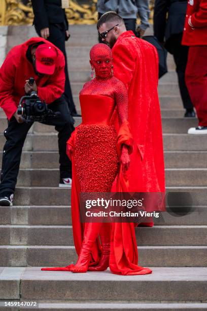 Doja Cat wears red off shoulder dress, red boots outside Schiaparelli during Paris Fashion Week - Haute Couture Spring Summer : Day One on January...