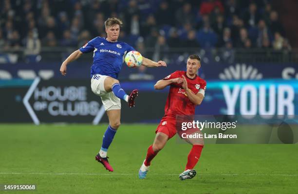 Marius Bulter of FC Schalke 04 controls the ball while under pressure from Willi Orban of RB Leipzig during the Bundesliga match between FC Schalke...