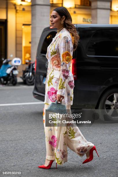Guest wears a floral print sequins blazer with matching pants, red heels and silver bag, outside Rahul Mishra, during Paris Fashion Week - Menswear...