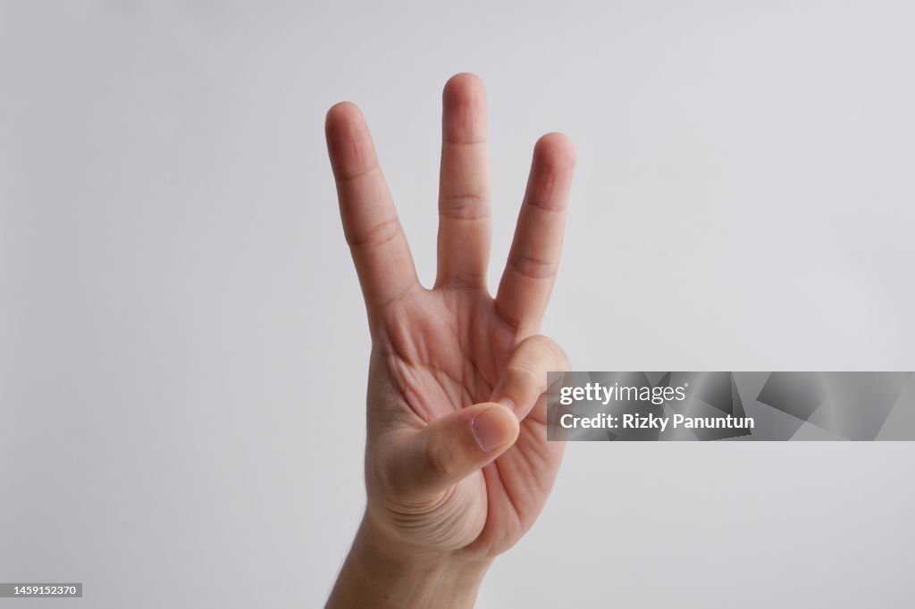 Cropped Hand Of Person Showing Number Three Against White Background