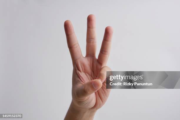 cropped hand of person showing number three against white background - third imagens e fotografias de stock