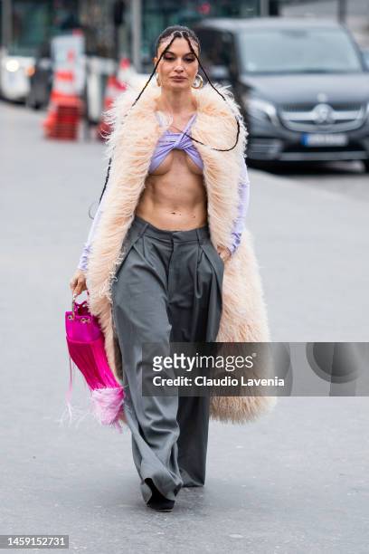 Angela Rozaz Saiz wears a lilac crop top, grey pants, peach fur long vest and fuchsia fringed bag, outside Georges Hobeika, during Paris Fashion Week...