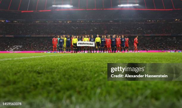 Players of Bayern Munich, FC Schalke 04 and referees line up with a banner reading "#WeRemember" prior to the Bundesliga match between FC Bayern...