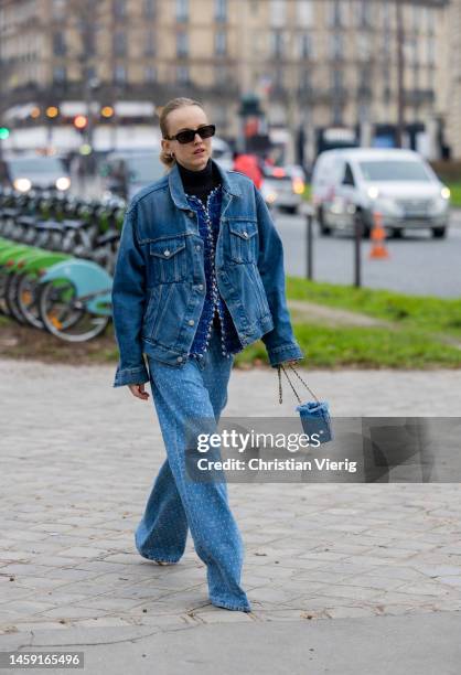 Alexandra Carl wears denim jacket, jeans with logo print, mini bag, black turtleneck, sunglasses outside Chanel during Paris Fashion Week - Haute...