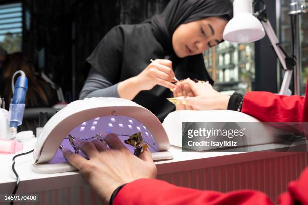 the manicurist is making new nails. manicure. beauty treatment and hand care - manicure set stock pictures, royalty-free photos & images