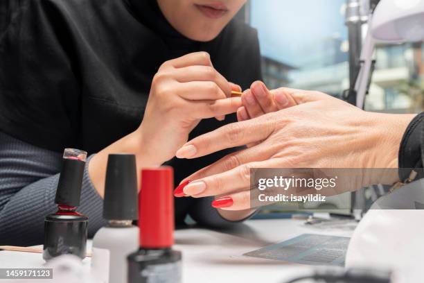 the manicurist is making new nails. manicure. beauty treatment and hand care - red nail polish stock pictures, royalty-free photos & images