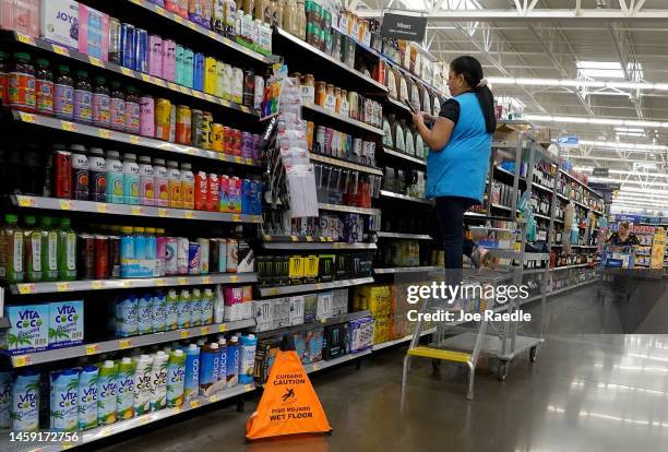 Worker stocks the shelves at a Walmart store on January 24, 2023 in Miami, Florida. Walmart announced that it is raising its minimum wage for store...