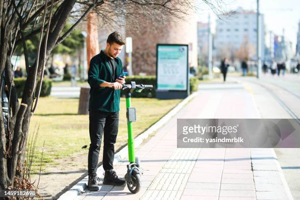 jeune homme louant un scooter dans la ville. concept de visite de la ville - rue 21 photos et images de collection