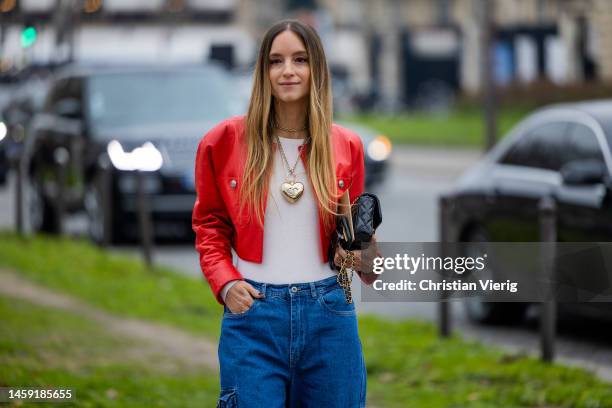 Charlotte Groeneveld wears red jacket, black bag, denim jeans with side pockets outside Chanel during Paris Fashion Week - Haute Couture Spring...