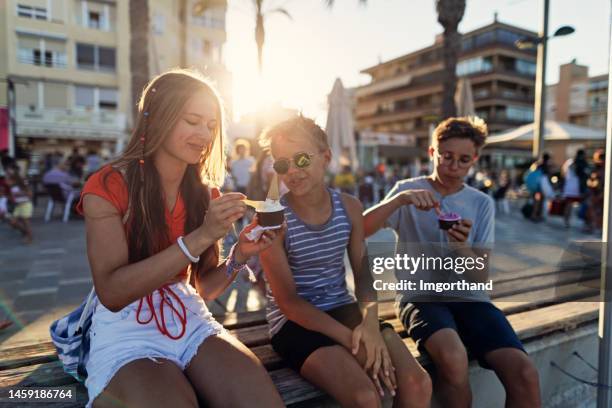 teenagers eating ice cream on beach promenade of alicante, spain - alicante street stock pictures, royalty-free photos & images