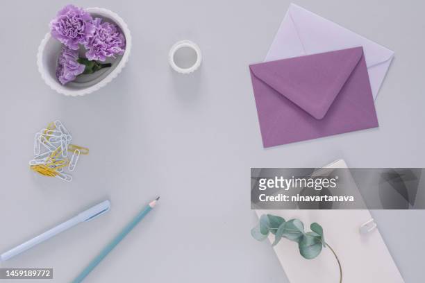 overhead view of purple carnation flower heads, envelopes and assorted stationery on a table - pencil skirt beautiful bildbanksfoton och bilder