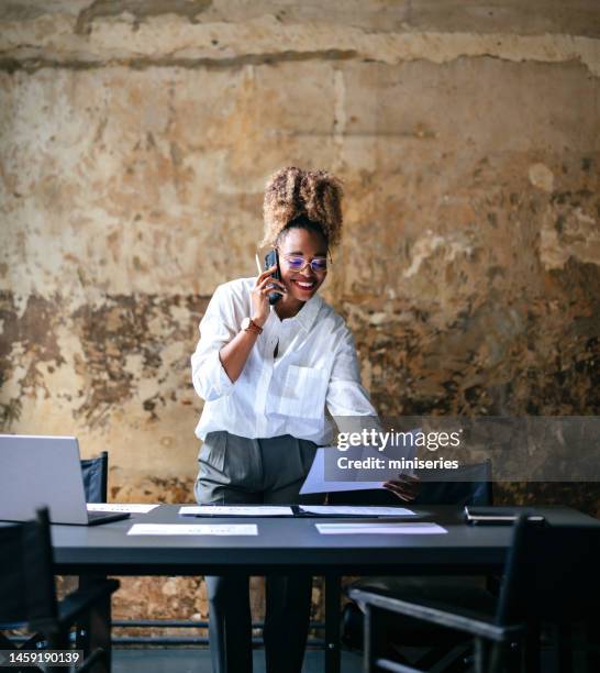 smiling businesswoman talking on a mobile phone in the cafe - talking phone stock pictures, royalty-free photos & images