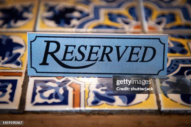 close-up of a reserved sign on tiled table - panneau espace réservé photos et images de collection