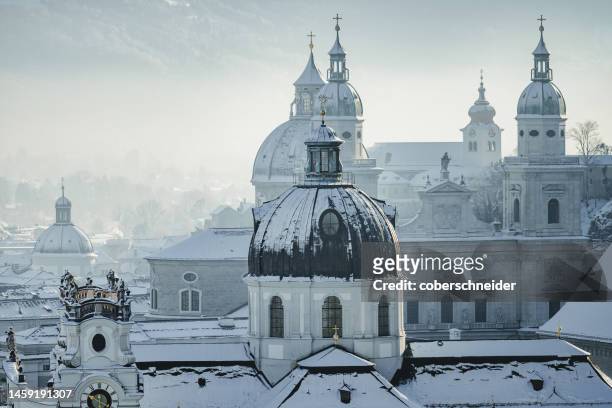 salzburg cathedral and city skyline in winter snow, salzburg, austria - salzburg winter foto e immagini stock