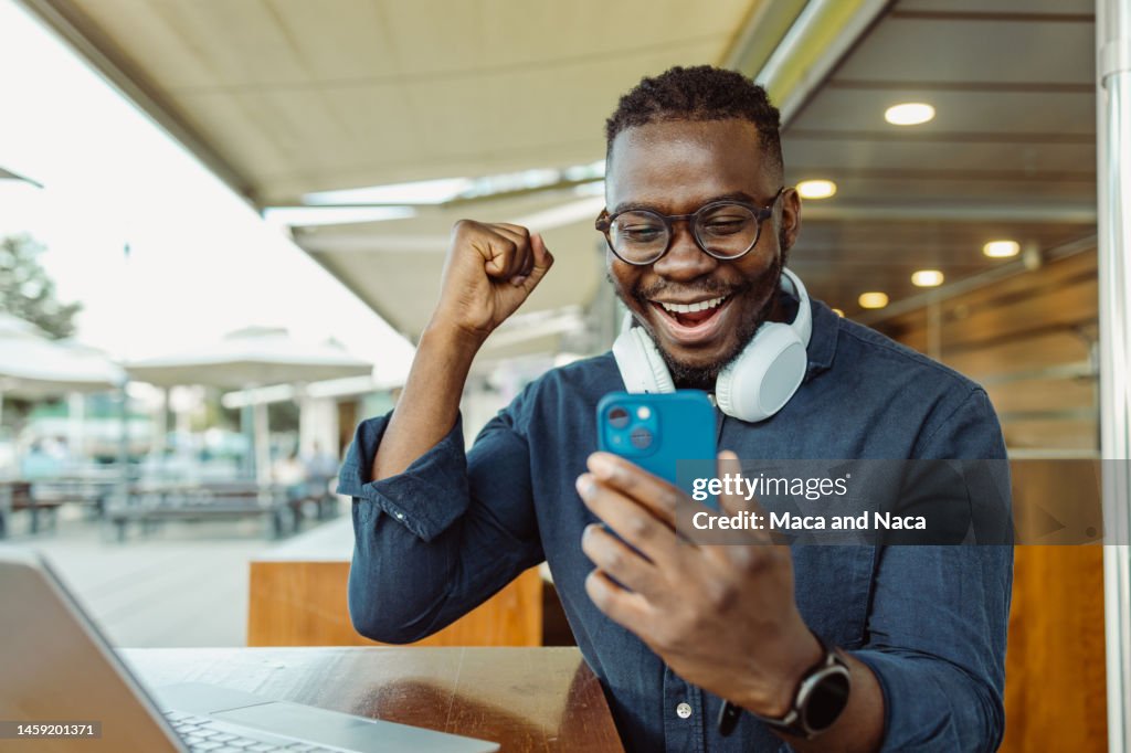 Happy young African-American man got a good news