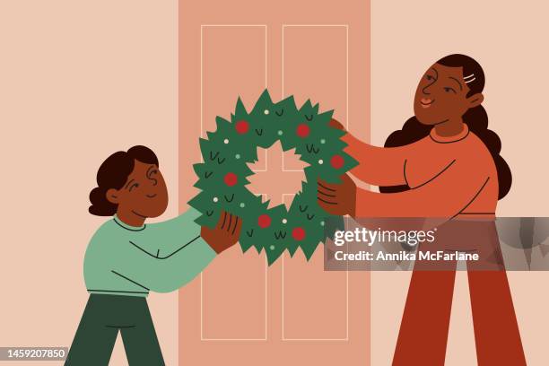 A Brother And Sister Work Together To Decorate Their Front Door With A Christmas Wreath High-Res Vector Graphic