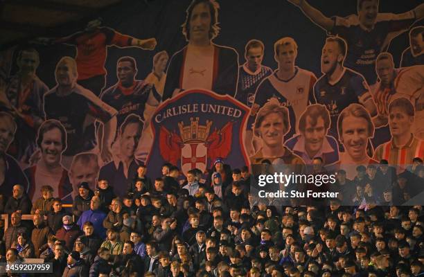 Carlisle United fans watch the action from behind the goal infront of a mural of former Carlisle players during the Sky Bet League Two between...