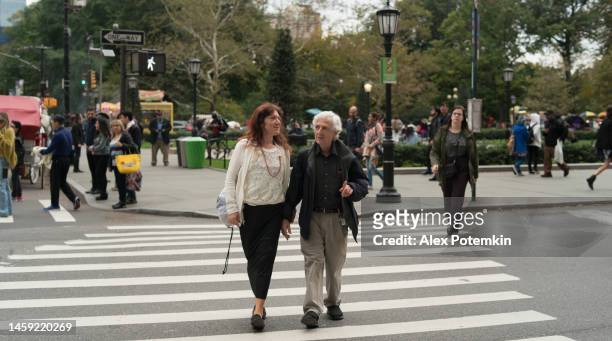allegra coppia anziana che attraversa la strada insieme e parla a manhattan, new york. - "alex potemkin" or "krakozawr" foto e immagini stock