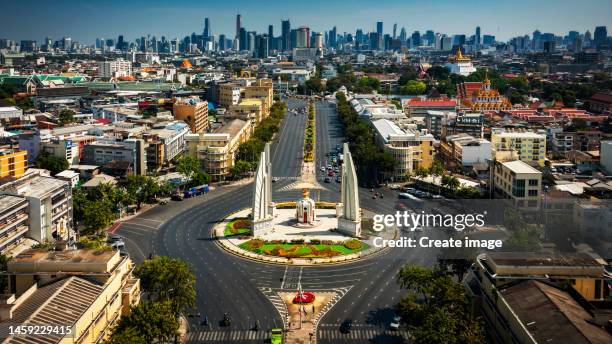 aerial view road around the democracy monument at ratchadamnoen road in bangkok with cityscape background, thailand. - democracy monument bangkok stock-fotos und bilder