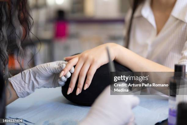 manicurist applying acrylic on nails - artificial nails stock pictures, royalty-free photos & images