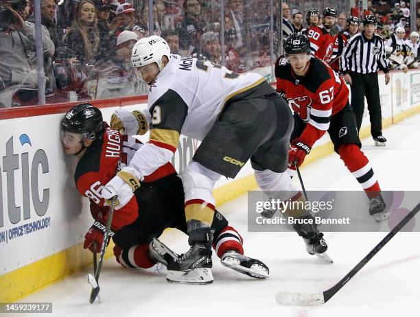 Brayden McNabb of the Vegas Golden Knights hits Jack Hughes of the New Jersey Devils into the boards during overtime at the Prudential Center on...