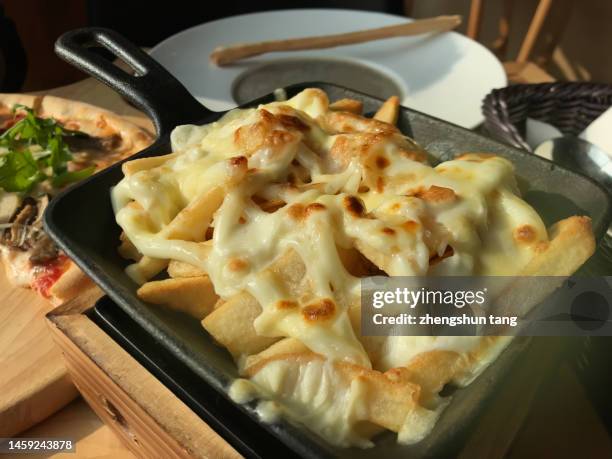 cheese fries and pizza on the table. - fried potato stock pictures, royalty-free photos & images