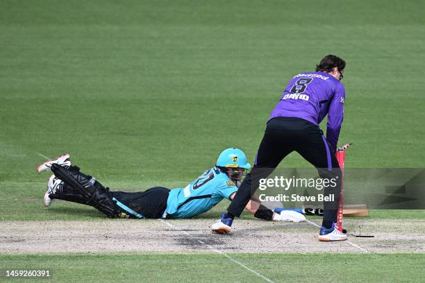 Tim David of the Hurricanes runs out Matthew Kuhnemann of the Heat during the Men's Big Bash League match between the Hobart Hurricanes and the...