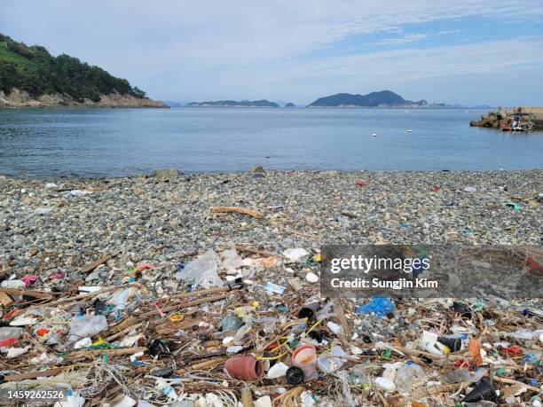 a beach covered with garbage - plastic stock pictures, royalty-free photos & images