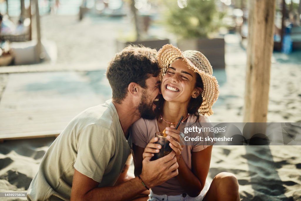 Young happy couple in love having fun in a beach café.