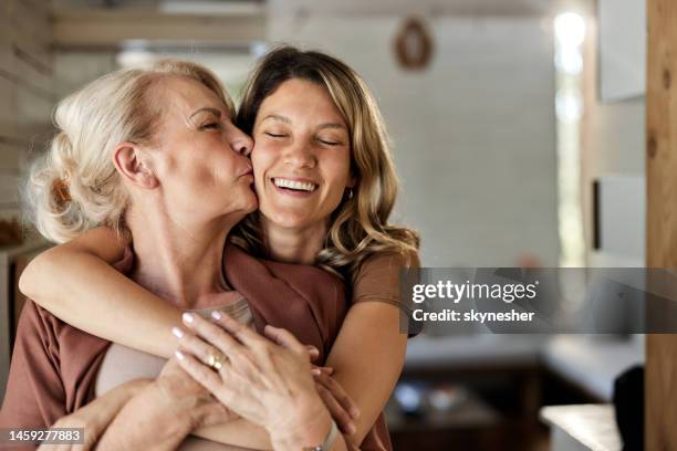 portrait of loving senior mother and her adult daughter at home. - mother and daughter stock pictures, royalty-free photos & images