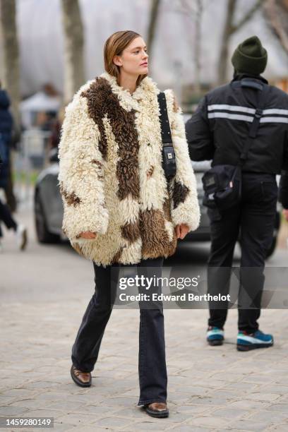 Guest wears a dark brown and white latte sheep oversized coat, black denim flared pants, a black shiny leather with Dior oblique print pattern...